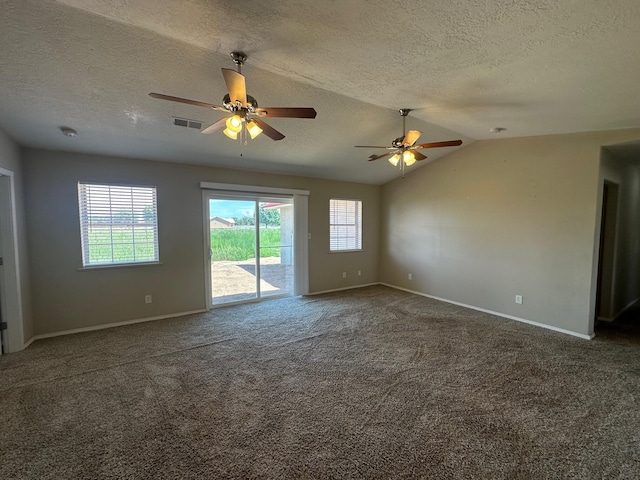 spare room featuring lofted ceiling, ceiling fan, a textured ceiling, and dark colored carpet