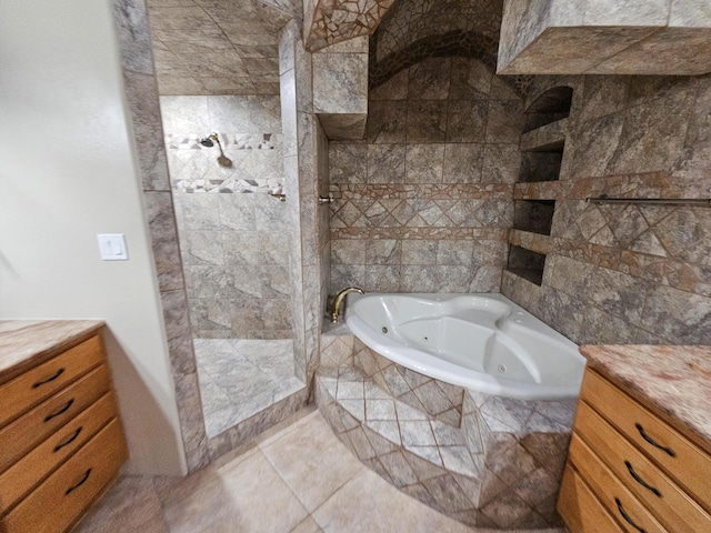 bathroom with a jetted tub, tile patterned flooring, and tiled shower