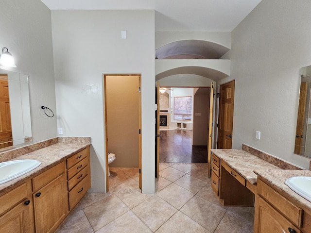 full bathroom with a sink, tile patterned flooring, two vanities, and toilet