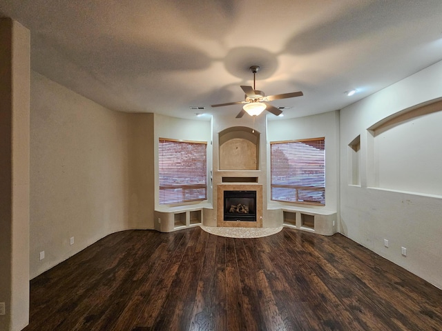 unfurnished living room with a glass covered fireplace, wood finished floors, and a ceiling fan