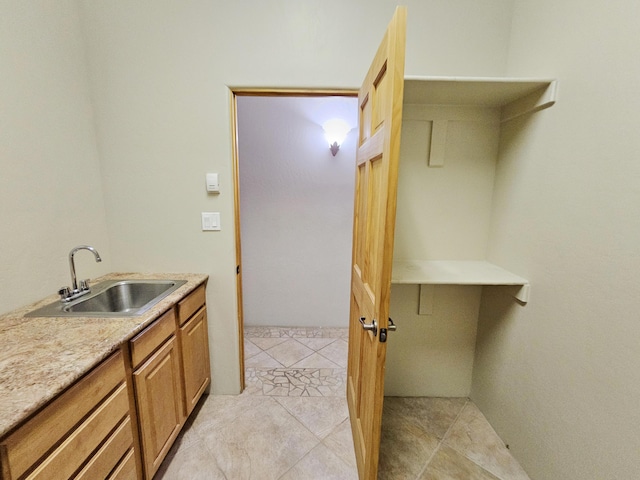 laundry area with light tile patterned flooring and a sink