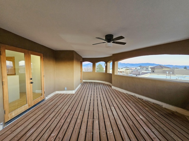 deck featuring french doors, a mountain view, and ceiling fan