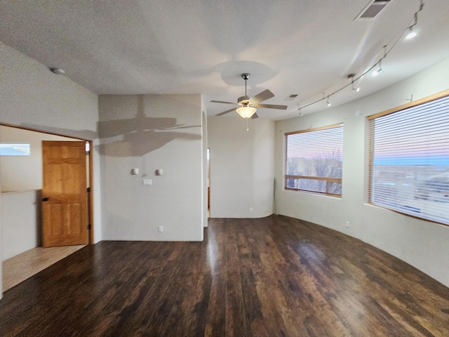 unfurnished living room featuring a textured ceiling, visible vents, dark wood finished floors, and a ceiling fan