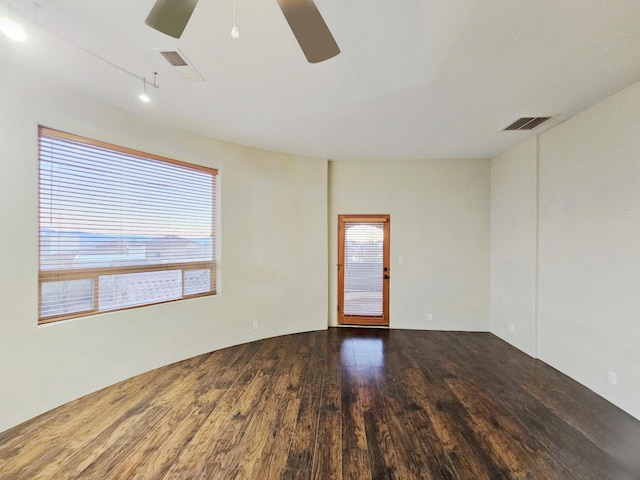 unfurnished room featuring ceiling fan, wood finished floors, and visible vents