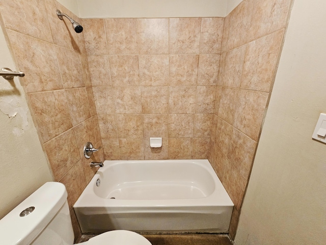 bathroom with toilet and tiled shower / bath combo