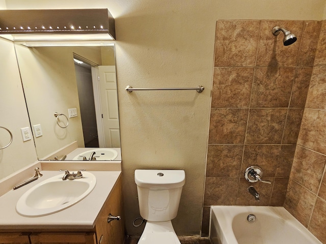 full bathroom with vanity, tiled shower / bath combo, and toilet