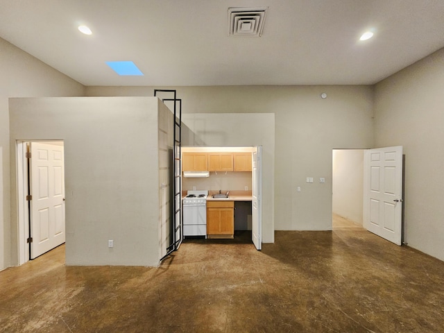 unfurnished living room featuring a high ceiling and sink