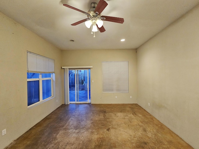 spare room featuring concrete flooring and ceiling fan