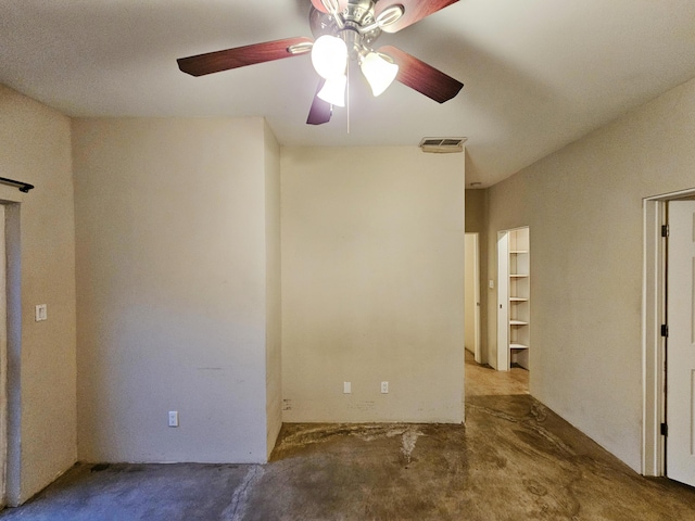 spare room featuring ceiling fan and concrete floors