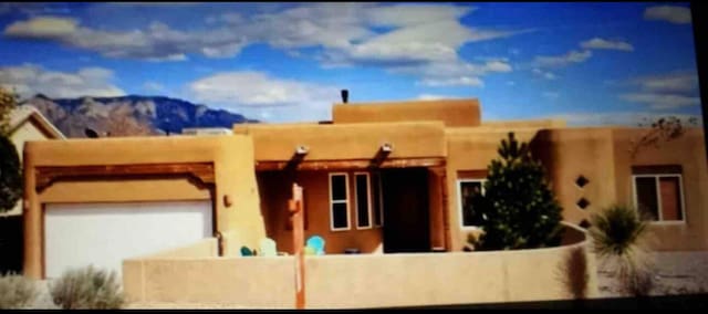 pueblo-style home featuring a mountain view and a garage