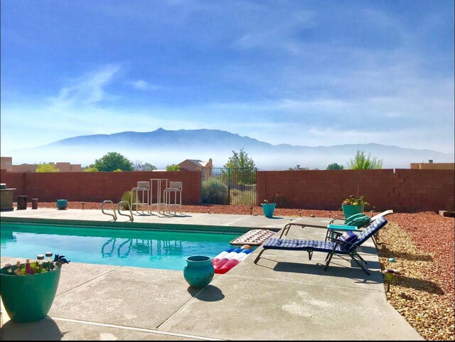 view of pool featuring a mountain view and a patio