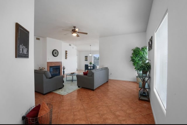 living room featuring ceiling fan, light tile patterned floors, and a fireplace