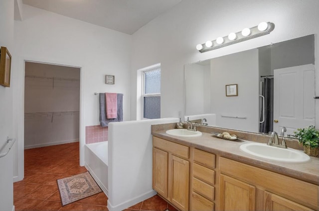 bathroom with vanity, tiled bath, and tile patterned flooring