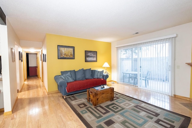 living room featuring light hardwood / wood-style flooring and a textured ceiling