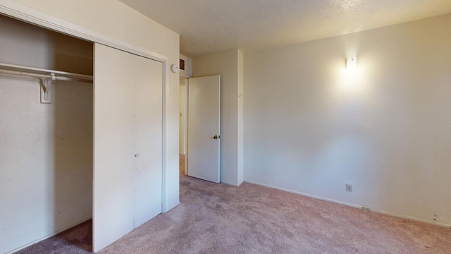 unfurnished bedroom featuring light carpet and a closet