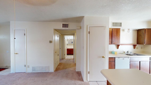 kitchen with white dishwasher, sink, light colored carpet, and a textured ceiling