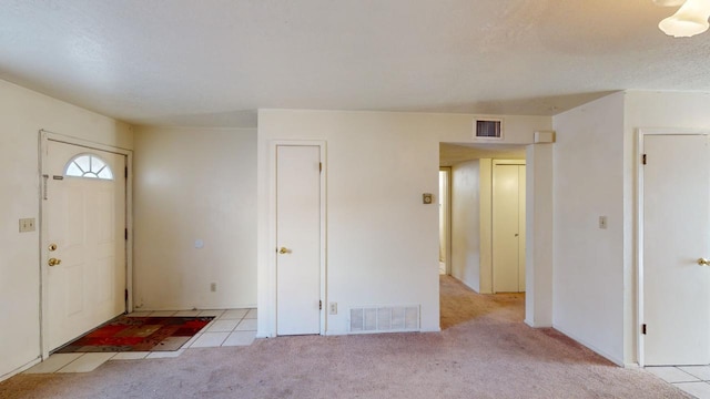 foyer entrance with light colored carpet