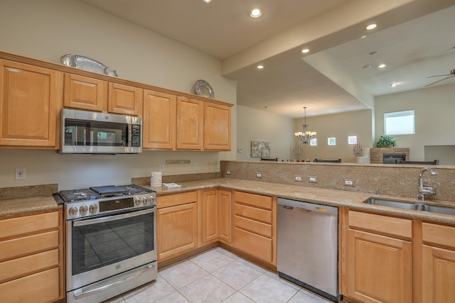 kitchen with sink, light tile patterned floors, appliances with stainless steel finishes, ceiling fan with notable chandelier, and decorative light fixtures