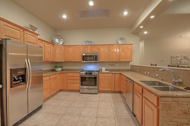 kitchen with sink, stainless steel appliances, kitchen peninsula, and light brown cabinets