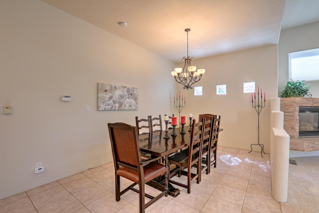 tiled dining space with an inviting chandelier and a fireplace