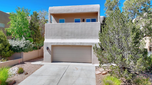 pueblo revival-style home featuring a garage