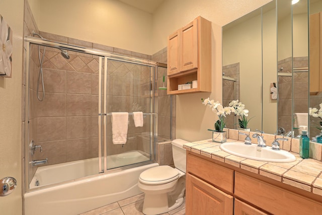 full bathroom with tile patterned flooring, vanity, shower / bath combination with glass door, and toilet