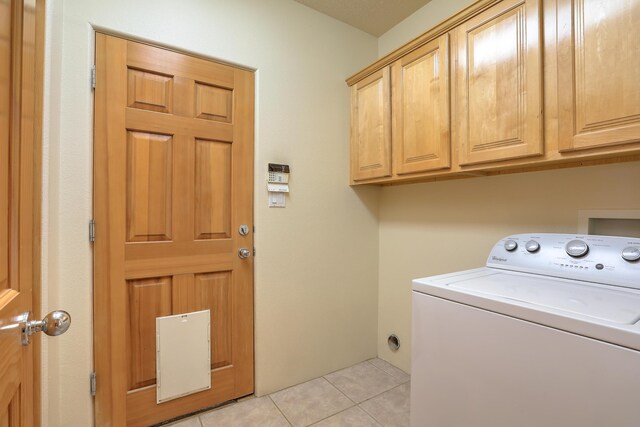 laundry area with light tile patterned flooring, cabinets, and washer / clothes dryer