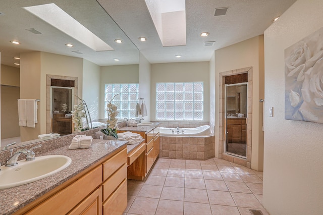 bathroom featuring tile patterned floors, shower with separate bathtub, a skylight, a textured ceiling, and vanity