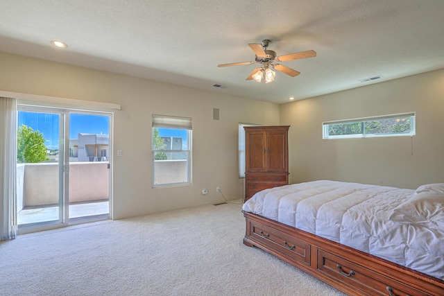 bedroom with multiple windows, light carpet, access to exterior, and ceiling fan