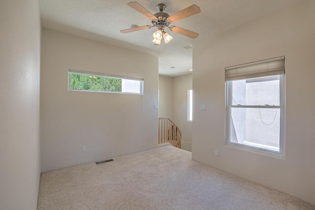 carpeted spare room with ceiling fan