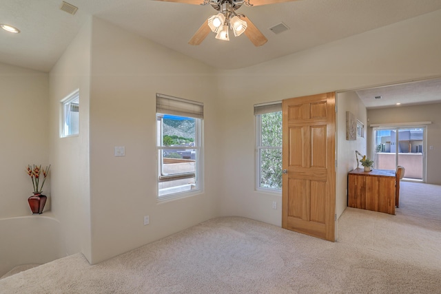 interior space with vaulted ceiling, light carpet, and ceiling fan