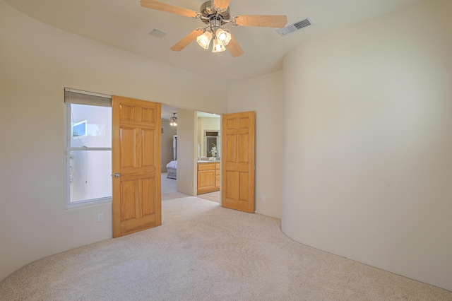 carpeted spare room featuring ceiling fan