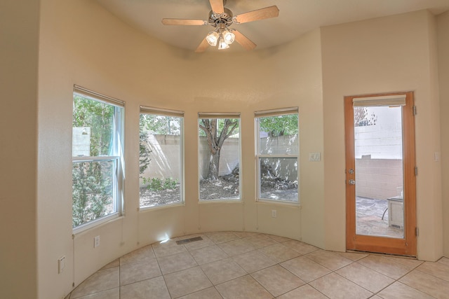 unfurnished sunroom with ceiling fan and a healthy amount of sunlight