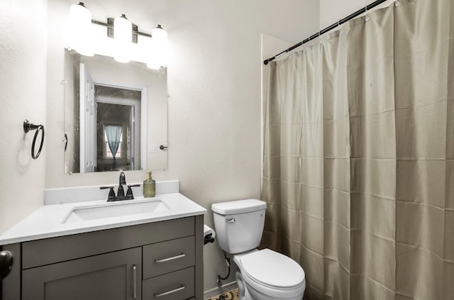 bathroom with vanity, curtained shower, and toilet