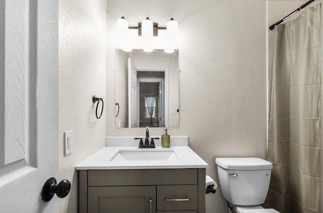 bathroom with vanity, toilet, and curtained shower