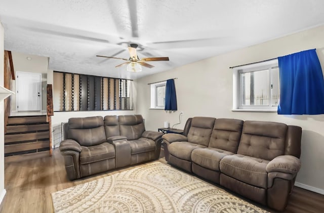 living room with wood-type flooring, a textured ceiling, and ceiling fan