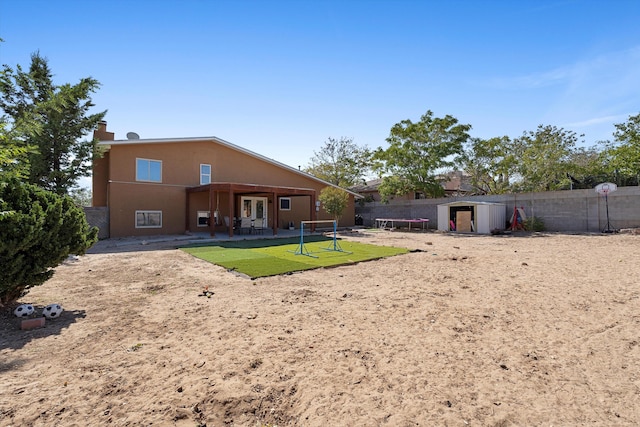 rear view of property with a storage shed and a yard