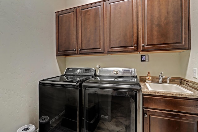 laundry room with sink, washer and clothes dryer, and cabinets