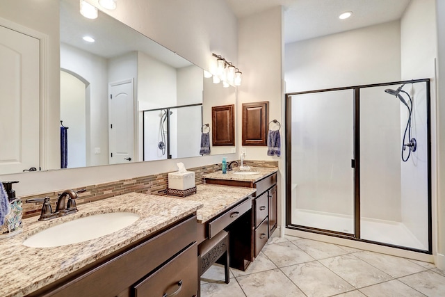 bathroom with vanity and a shower with shower door