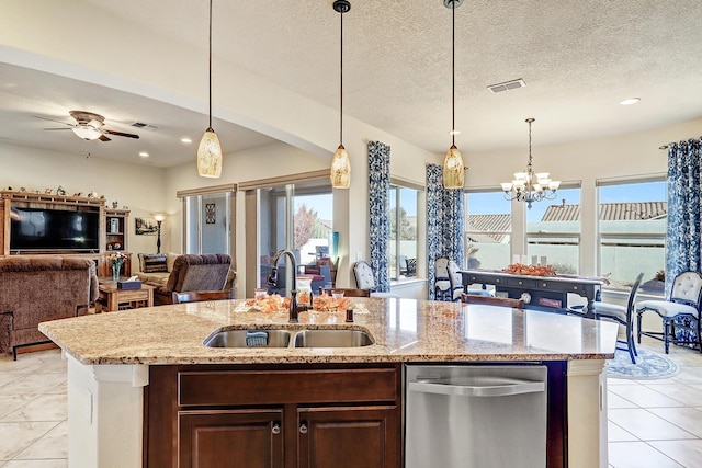 kitchen featuring sink, dishwasher, pendant lighting, light stone countertops, and ceiling fan with notable chandelier