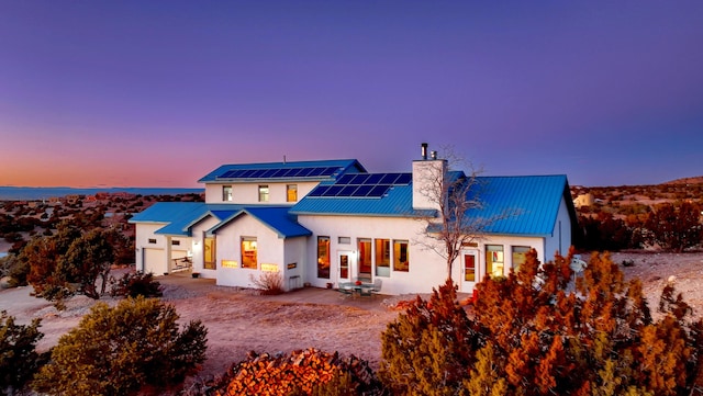 back house at dusk featuring solar panels