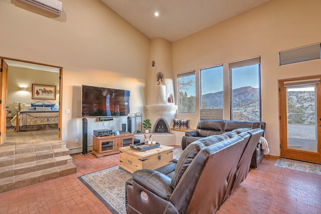 living room featuring a towering ceiling, a baseboard radiator, a wall unit AC, and plenty of natural light