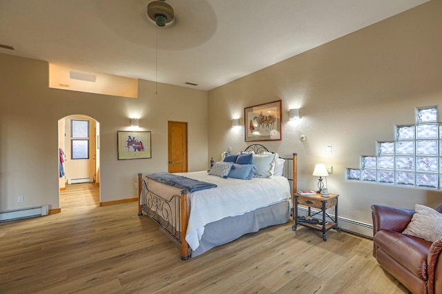 bedroom featuring baseboard heating, ceiling fan, and hardwood / wood-style flooring