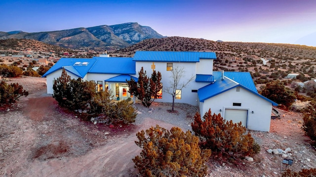 aerial view at dusk featuring a mountain view