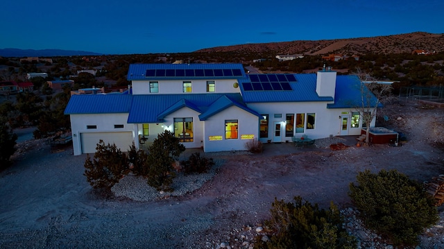 view of front of house featuring a garage, a mountain view, and solar panels