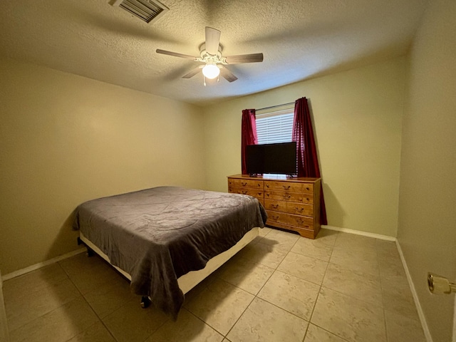 tiled bedroom featuring ceiling fan and a textured ceiling