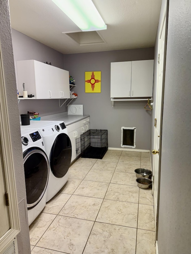 washroom featuring light tile patterned floors, cabinets, and washing machine and clothes dryer