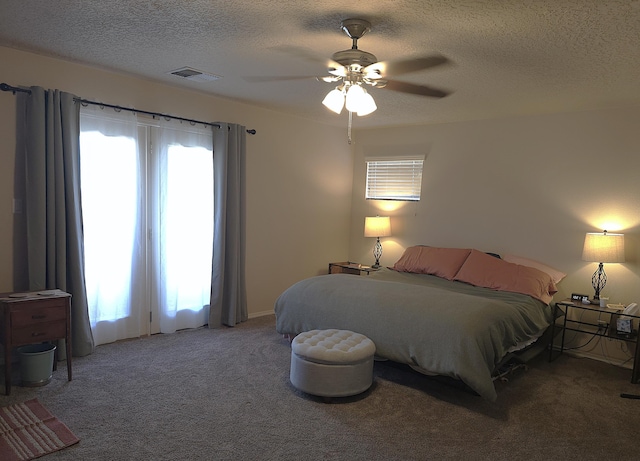 bedroom with ceiling fan, a textured ceiling, and carpet flooring