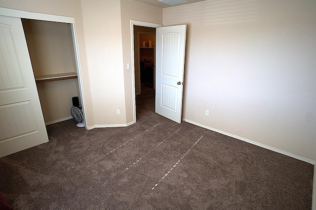 unfurnished bedroom featuring a closet and dark colored carpet