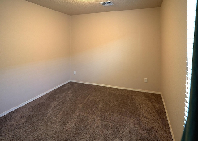 carpeted spare room with a textured ceiling